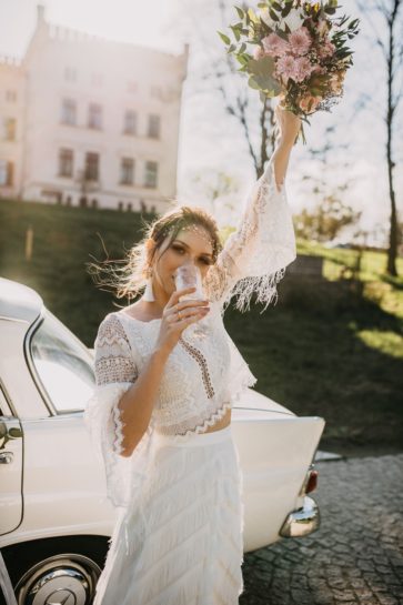Panna Młoda w stylizacji boho wznosząca toast szampanem i unosząca pastelowy bukiet, What a lovely day Wedding Planner Poznań